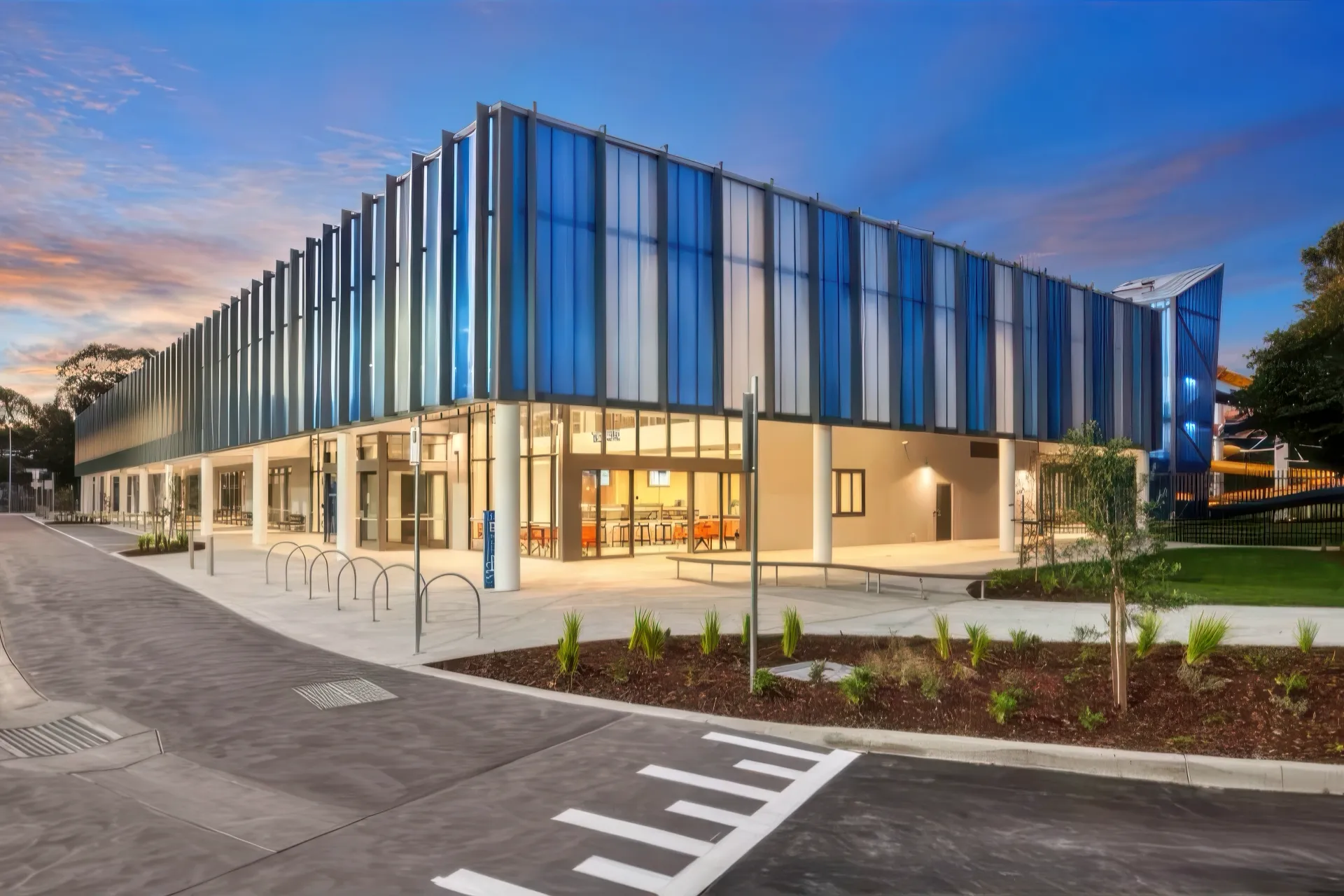 Gippsland Regional Aquatic Centre — translucent blue facade at dusk
