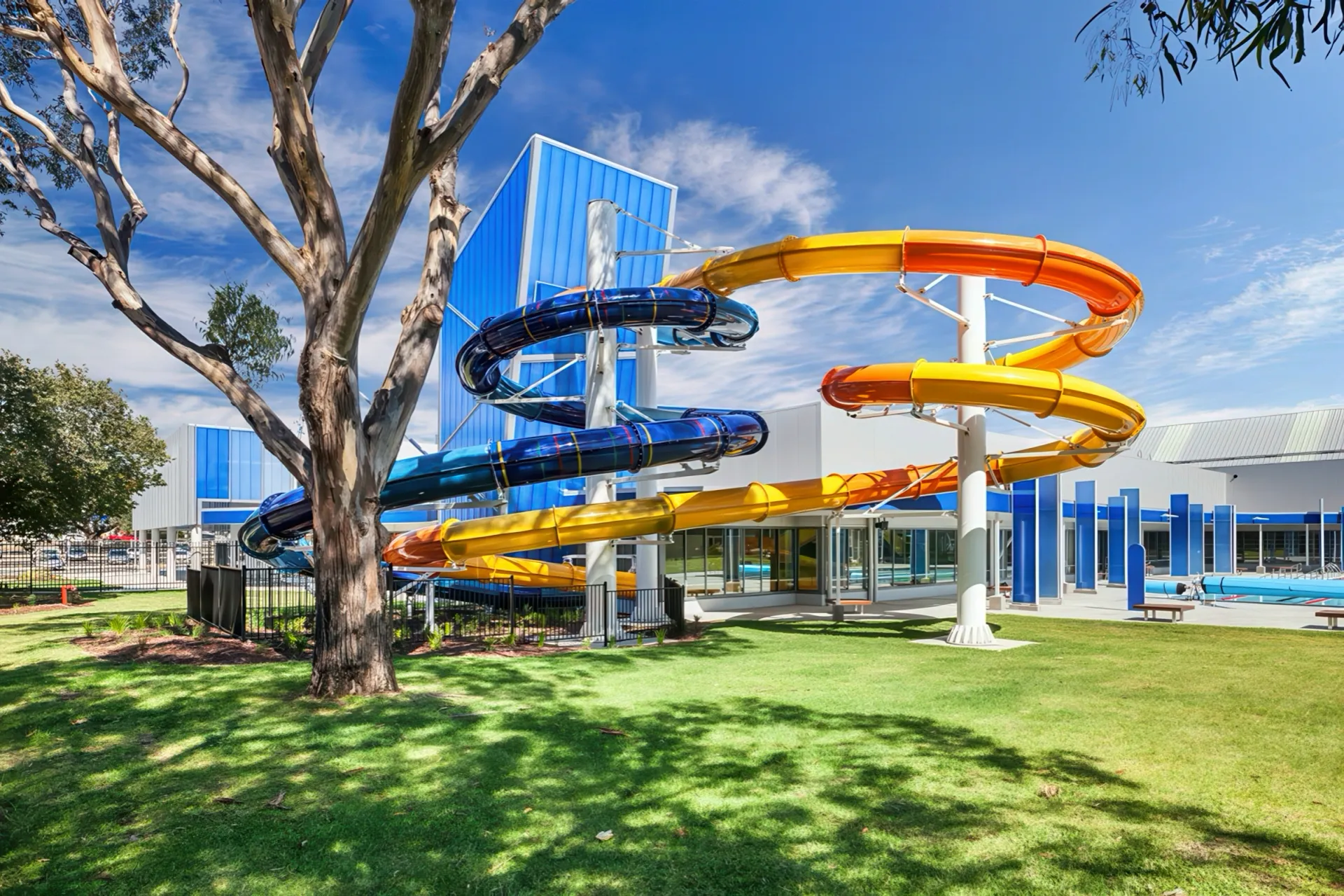 Outdoor waterslides winding through eucalypt parkland at a regional aquatic centre