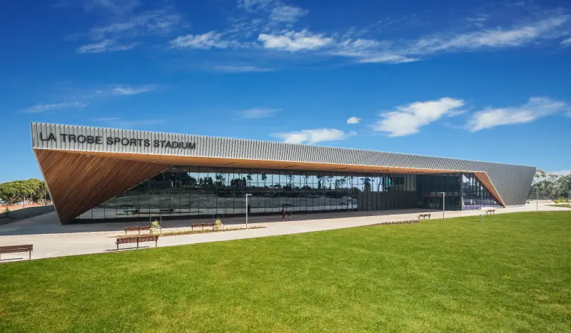 La Trobe Sports Stadium exterior with angular timber-clad facade beneath a clear blue sky